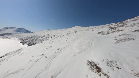 Aerial Fpv Drone Cinematic View Flying Over Picturesque Snowy Mountain Terrain Surrounded By Cliff alt
