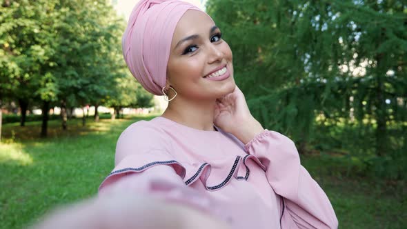 Young Muslim Woman in Headscarf Makes Selfie Using Camera alt