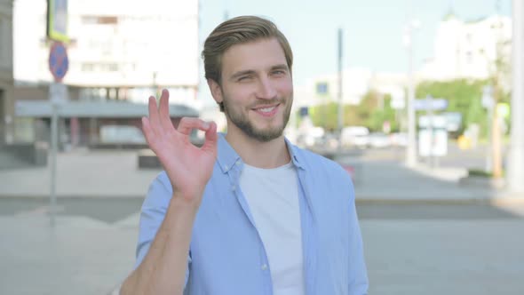 Man Showing Ok Sign with Finger Outdoor alt