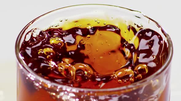 Two Ice Cubes Falling Into Glass with Whiskey. Slow Motion alt