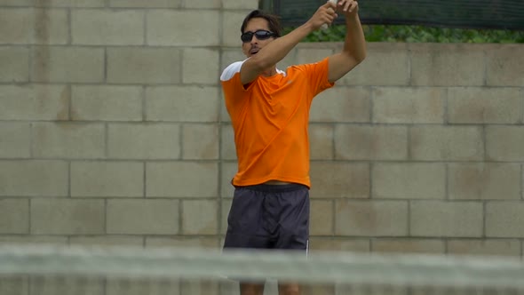 Two men playing outdoor tennis together. alt