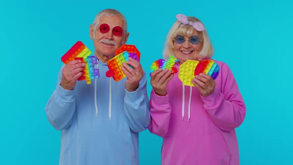 Smiling Senior Old Grandmother Grandfather Holding Antistress Touch Screen Push Pop It Popular Toy alt