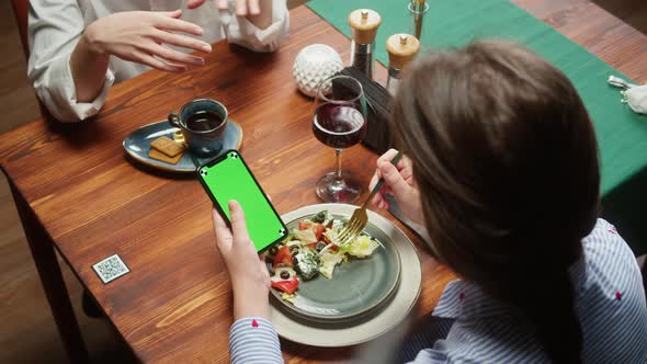 Woman Using Smartphone with Chroma Green Screen and Eating Salad alt