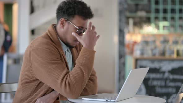 African Man Having Loss While Using Laptop Cafe alt