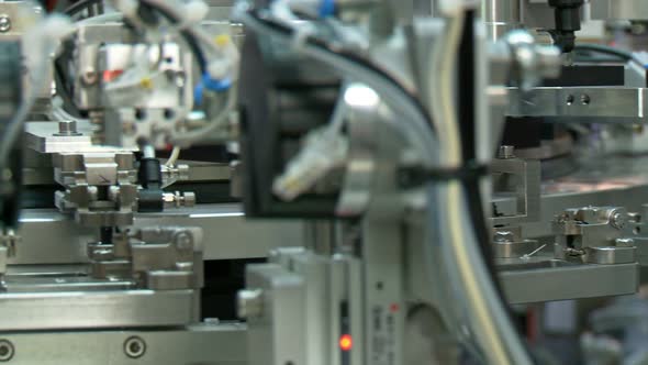 Advanced industrial production line for small parts, robotic arms working alt