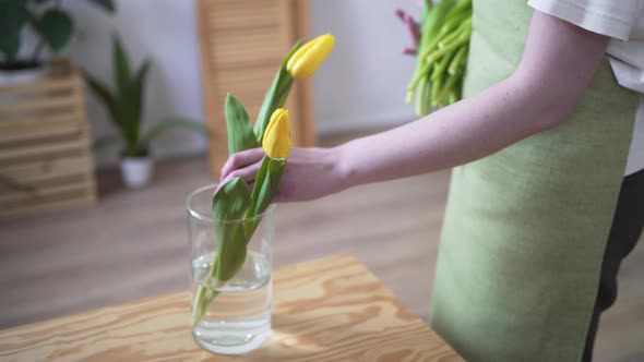 Florist Places Yellow Flowers in a Transparent Vase