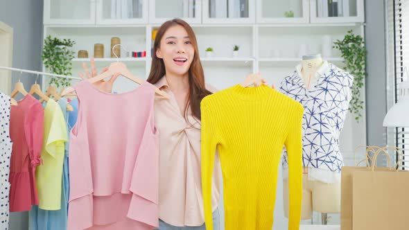 Asian beautiful woman sell cloth product online live streaming at home. alt