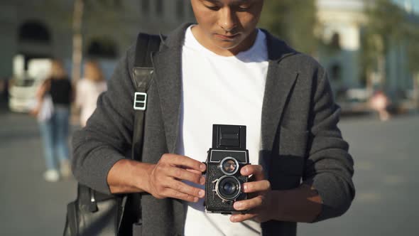 Real Time Portrait Shot of a Young Asian Man Taking a Picture on an Old Camera. Moscow Is the alt