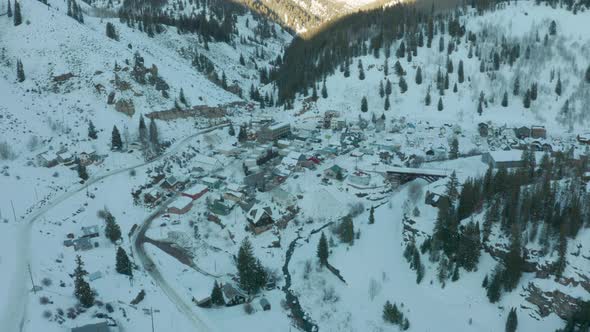 Aerial Drone Shot Approaching Small Mountain Town in Snowy Colorado Valley