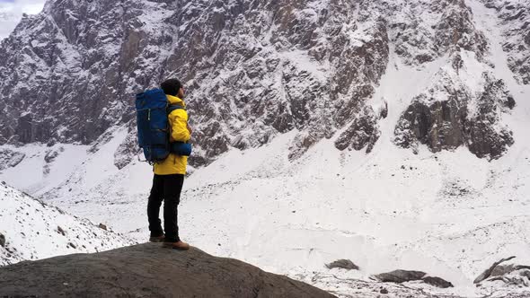 Tourist on Mountain Top. Sport and Active Life. Hiker with Backpack Standing on Top of a Mountain alt