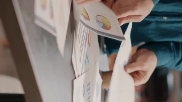 Close Up of Colleagues Analyzing Data Rate Charts on Papers alt
