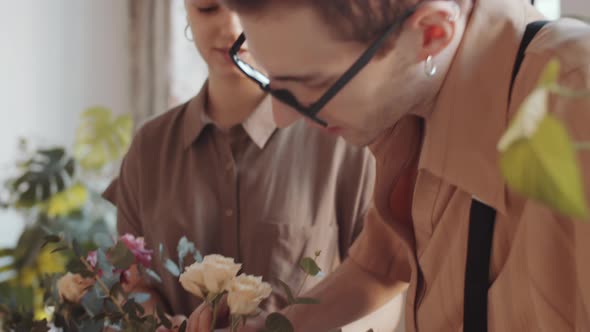 Young Male and Female Florists Making Flower Composition in Hatbox alt