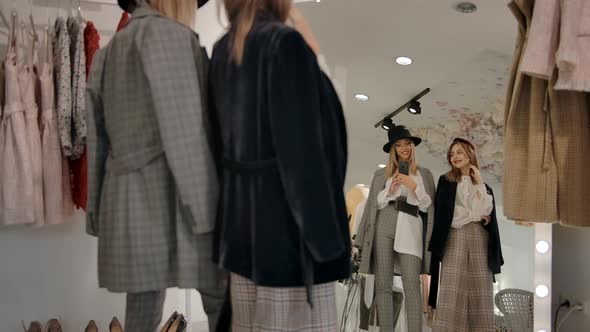 Young Women Trying on Outfit and Taking Photo with Phone alt
