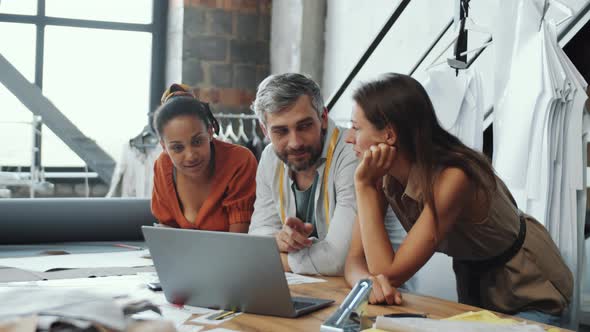 Multiethnic Fashion Designers Posing for Camera in Tailoring Studio alt
