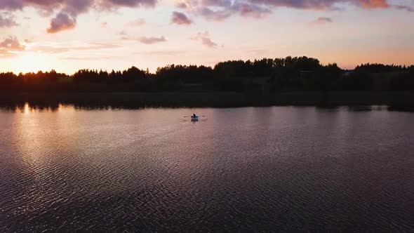 Man on Paddle Boat Sunset on Lake