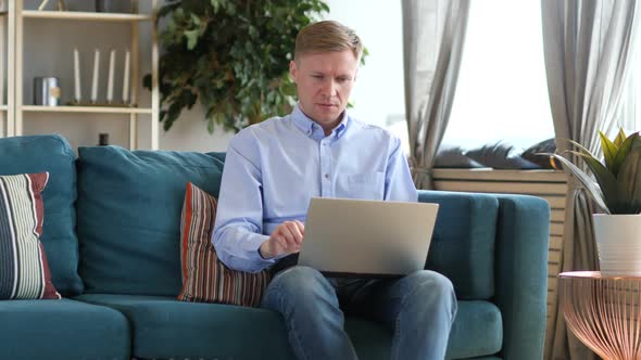 Middle Aged Man Excited for Success Working on Laptop alt