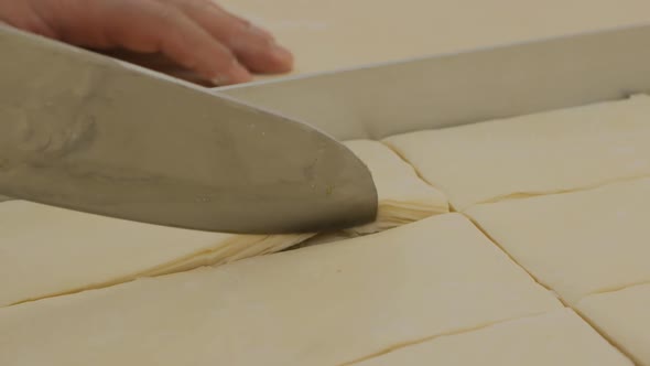 a Baker Demonstrates How Many Layers of Dough the Turkish Baklava Has with a Large Knife alt