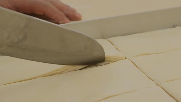 a Baker Demonstrates How Many Layers of Dough the Turkish Baklava Has with a Large Knife
