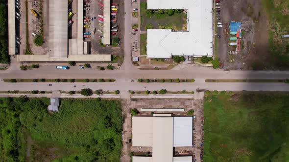 Cars and buses arrive at a local bus terminal with with shadows of clouds can be seen alt