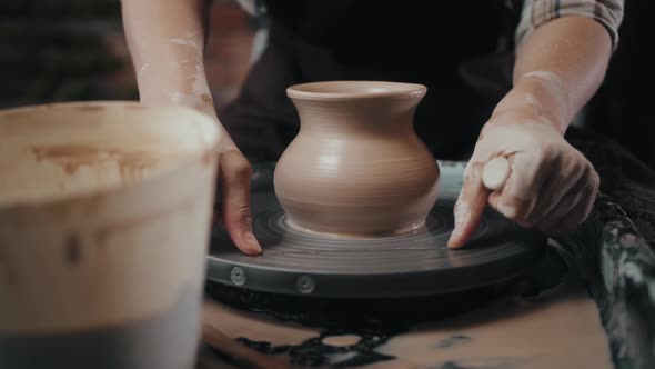 Man Potter Working on Potters Wheel Making Ceramic Pot From Clay in Pottery Workshop alt