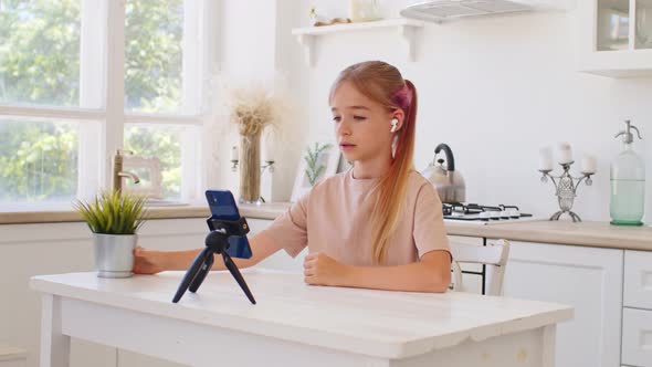 Teen Girl Having a Video Call Via Smartphone at Home in Kitchen