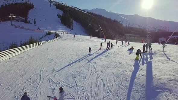 Many Skiers on the Ski Slope on a Sunny Day