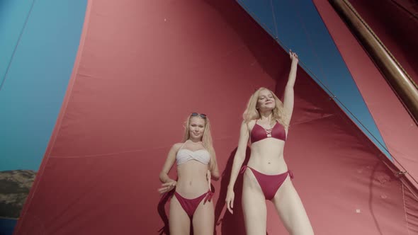Pretty Girls are Dancing During a Party on the Sailboat alt