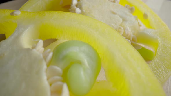 Sliced Rings of Fresh Raw Yellow Bell Peppers on Wooden Board alt