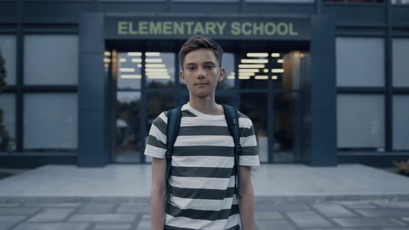 Closeup Serious Teen Boy Standing at Schoolyard alt