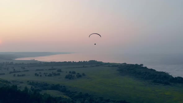 Waterscape with Green Plains and the Paraplane Flying Along alt
