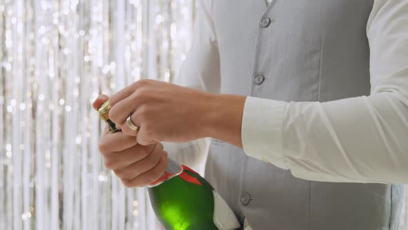 Young man opening champagne alt