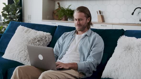 Middle Aged Man Chatting Online with a Smile on His Face alt