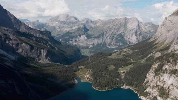 Descending drone shot over Blue Lake Oeschinen Kandersteg Switzerland mountains alt
