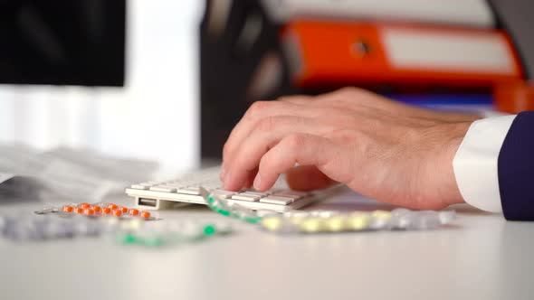 The man is researching pills on the computer. alt