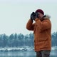 Adventure Photographer Takes Pictures of a Lake in the Winter Forest - VideoHive Item for Sale