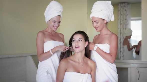 Young Women in Towels Have Fun Styling Their Hair and Talking alt