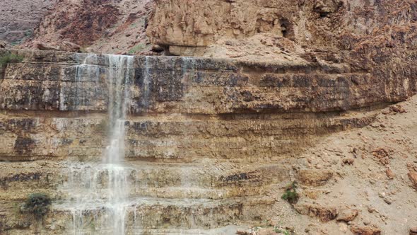 Israel, desert waterfall after rain, flood water, drone fly up reveal shot alt