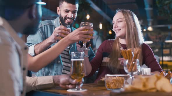 Multiracial friends meeting in the bar and drinking beer