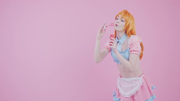 Caucasian Model Flirts With Camera By Slowly Blowing Shiny Bubbles Medium Long Studio Shot Pink alt