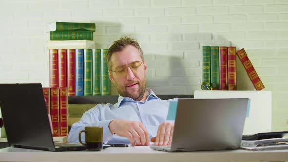 Middleaged Man is Lounging in the Office  He Makes a Paper Airplane and Launches It alt