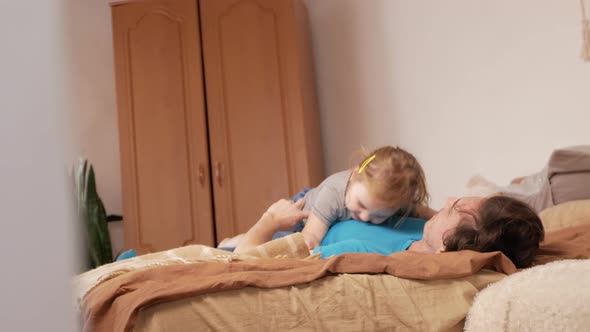 Dad and Daughter Play in Bedroom Happy Family on Bed alt