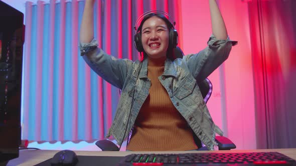 Excited Asian Girl Gamer Celebrates Victory While Playing Video Game On Computer alt