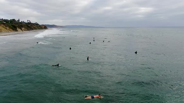 Aerial View of Surfers Waiting, Paddling and Enjoying Waves alt