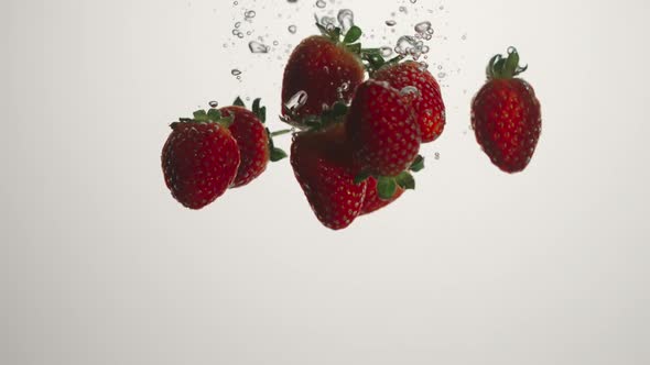 Strawberries Fall In Water On White Background