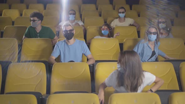 Man in Face Mask Coughing in Cinema on Covid-19 Pandemic. People Moving Aside From Ill Person in alt