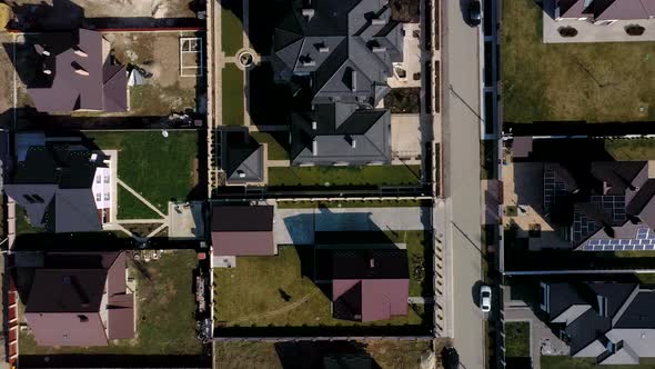 Aerial view of houses on housing estates, some with building on roof panels alt