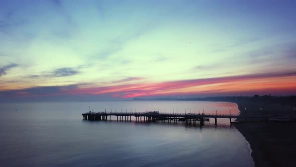 Early morning on the beach just before the sunrise. Drone footage. Orange and purple sky. Relaxing s alt
