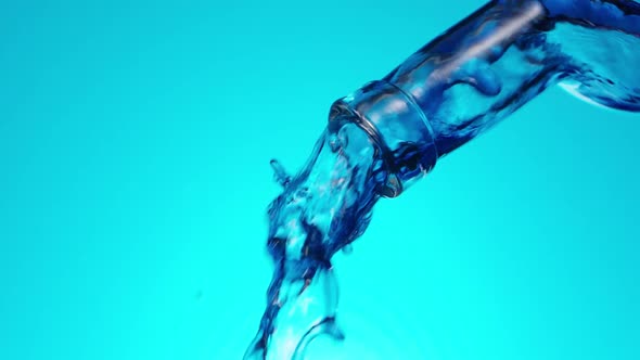 Purple Liquid Pouring From the Bottle on Blue alt