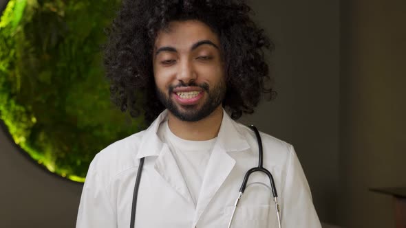 Arabian Doctor in Uniform with Stethoscope Talks to Camera alt