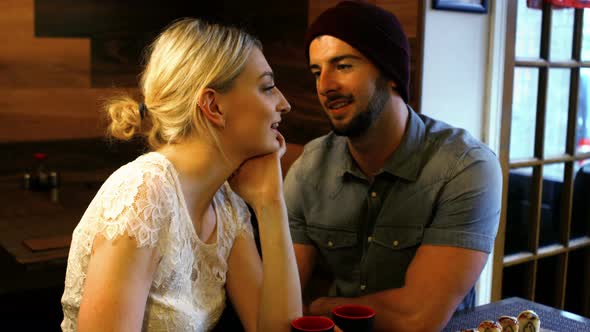 Couple interacting with each other in restaurant alt